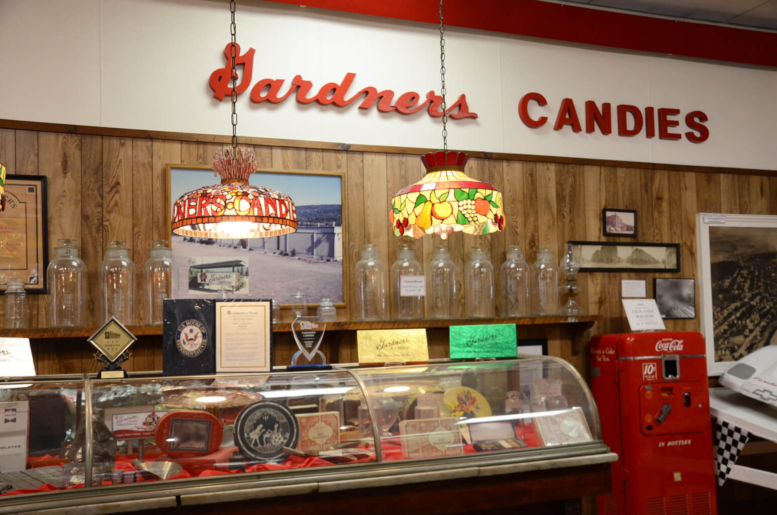 old fashioned display case with a gardners candies sign hanging on the wall